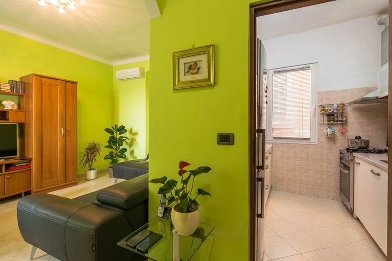 Cucina abitabile con pareti verdi in appartamento a Rovinj