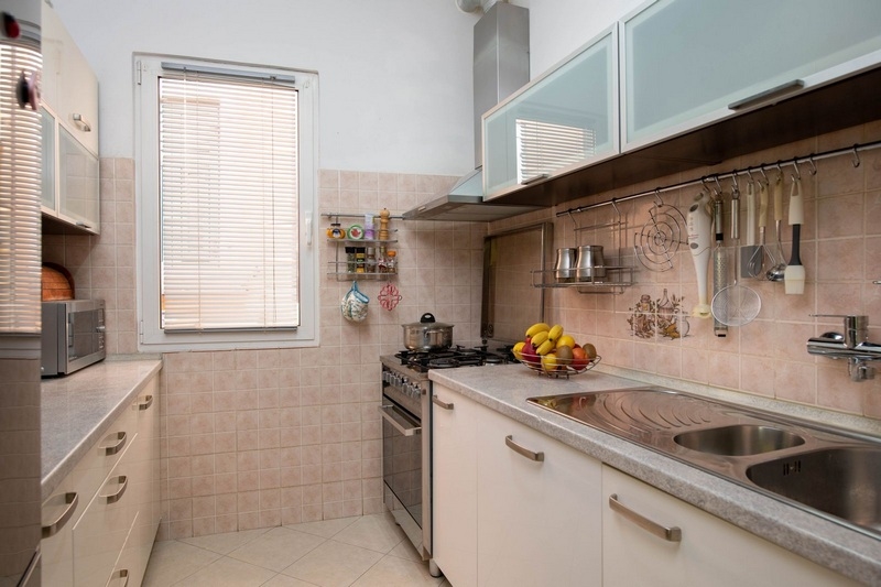 Cucina luminosa con armadi color crema a Rovinj