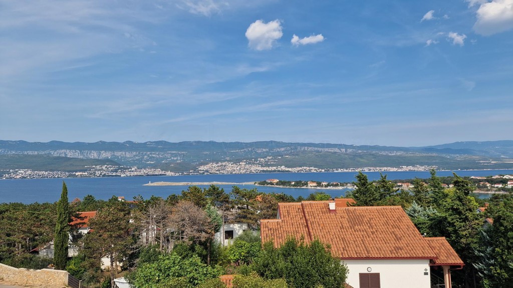 Vista su tetti e alberi verso baia e montagne