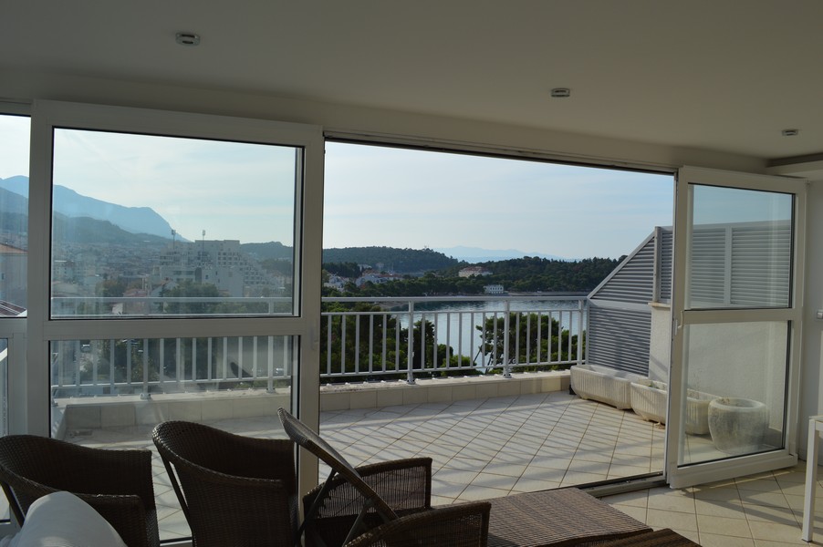 Loggia con mobili in vimini e vista su montagne e baia