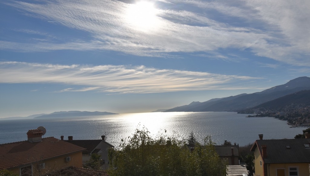Controluce sulla baia dietro i tetti di tegole