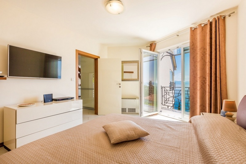 Camera da letto con porta del balcone e vista sull'acqua