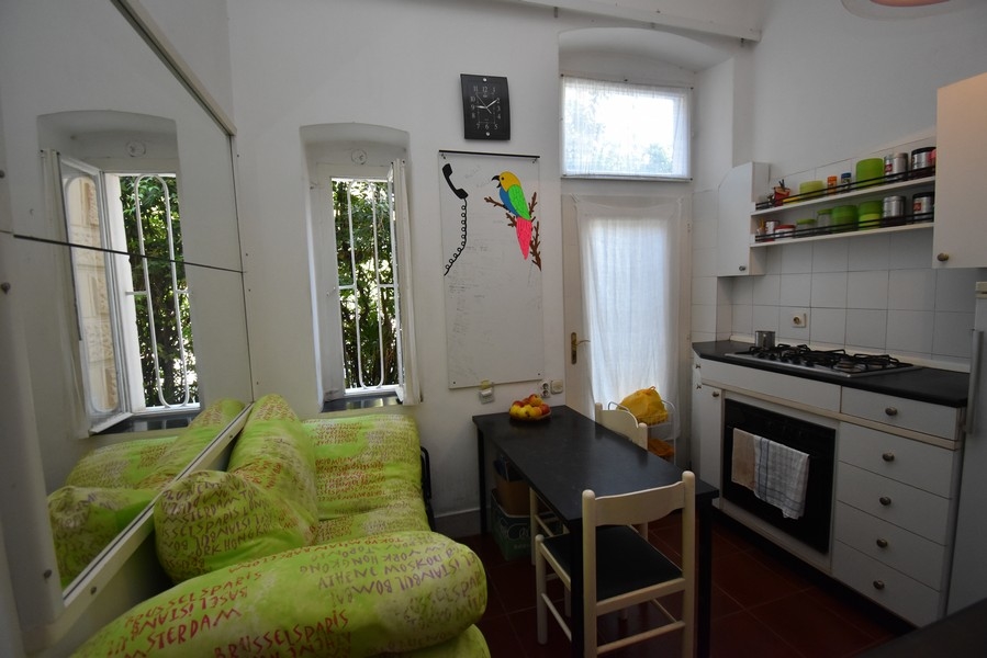 Cucina abitabile con divano verde e tavolo da pranzo alla finestra