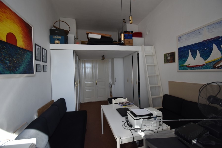 Stanza con letto a soppalco sotto il soffitto e scala