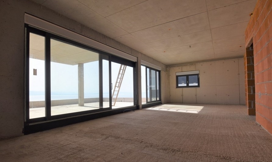 Ambiente al grezzo con vetrata e vista mare