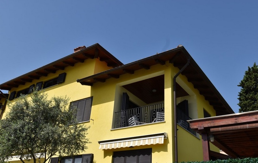 Casa gialla con loggia e ulivo davanti