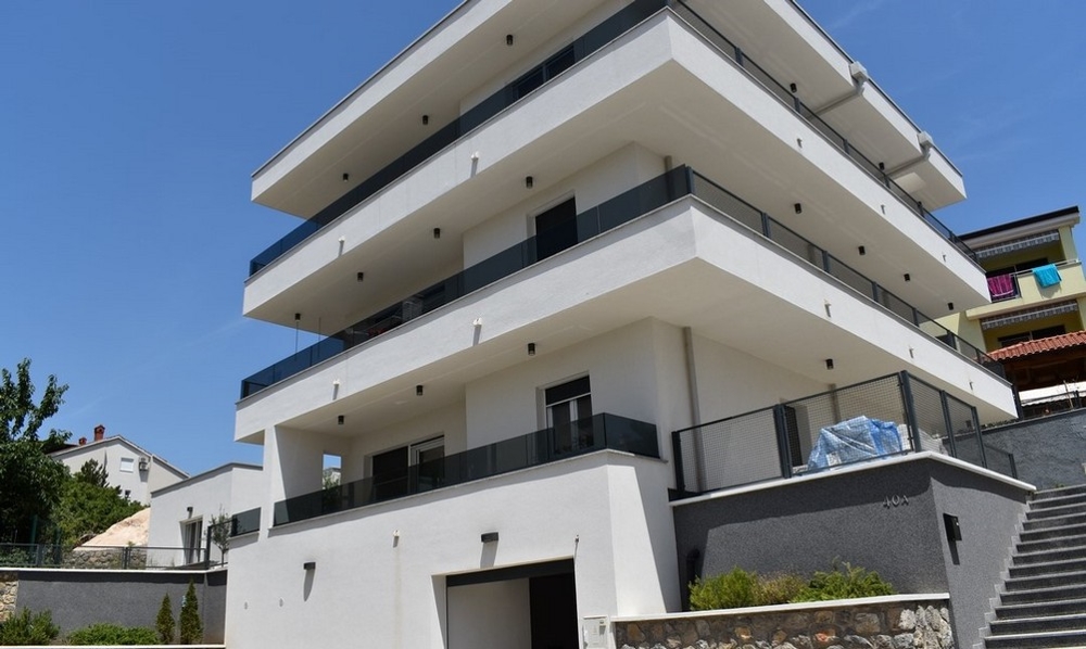 Appartamento al piano terra in nuovo edificio bianco con ampi balconi