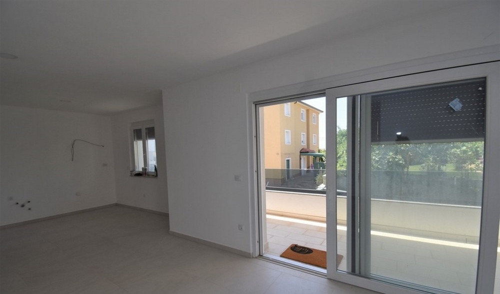 Stanza con porta scorrevole sulla terrazza e casa vicina dietro