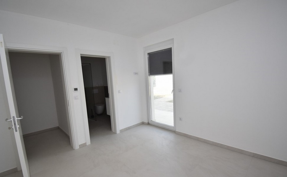 Stanza con porta della terrazza e passaggio verso il bagno