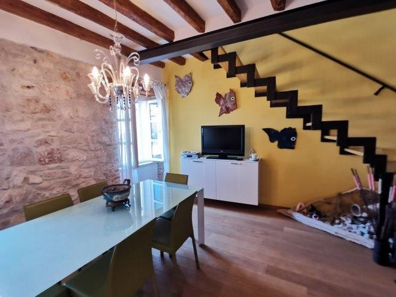 Zona giorno con lampadario e scala in maisonette a Rovinj