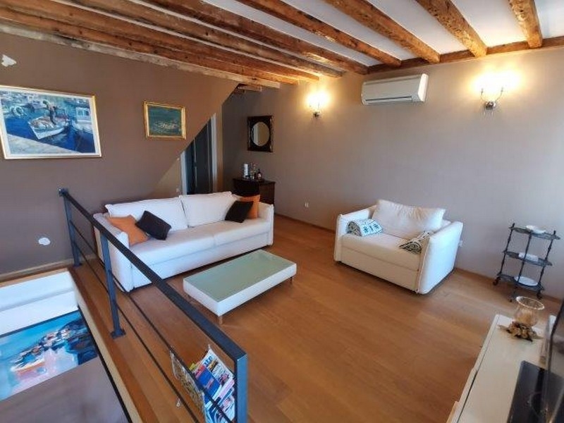 Zona notte nel loft con quadri e soffitto in legno a Rovinj