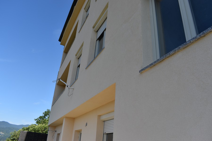 Vista laterale dell'edificio con tapparelle e davanzali