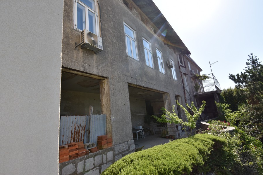 Lato della casa non intonacato con aperture dei garage