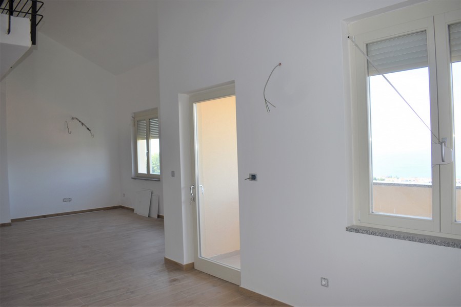 Stanza luminosa con soffitto alto e porta per la stanza accanto