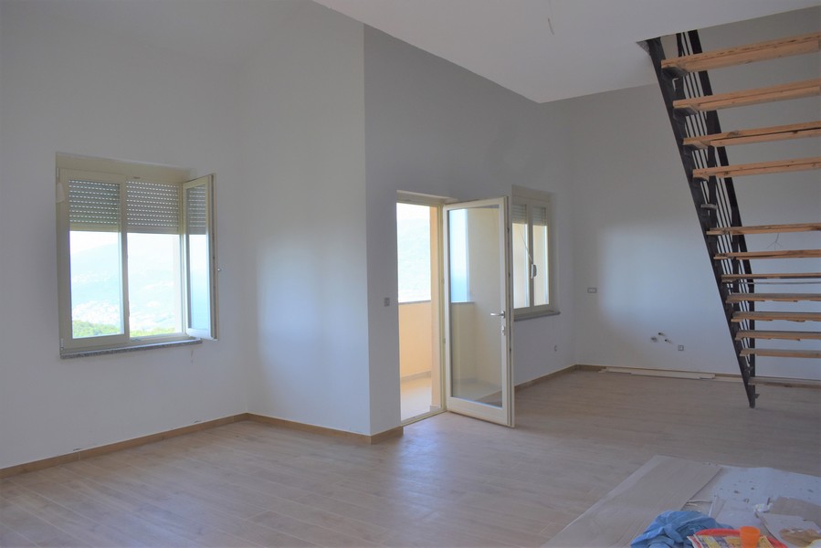 Stanza con porta del balcone e scala sotto il soffitto spiovente
