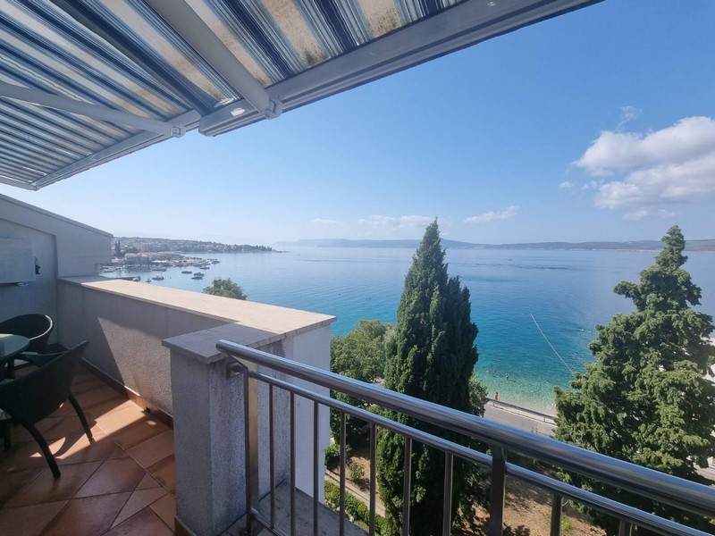 Balcone sotto la tenda da sole con vista su baia e spiaggia