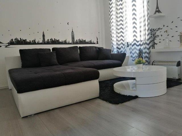 Zona giorno con divano nero e decorazioni moderne a Rovinj