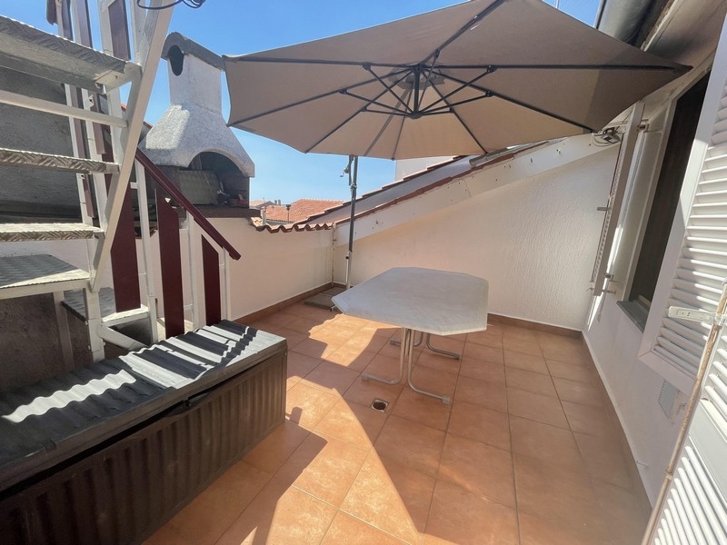 Terrazza con ombrellone e scala esterna accanto al camino
