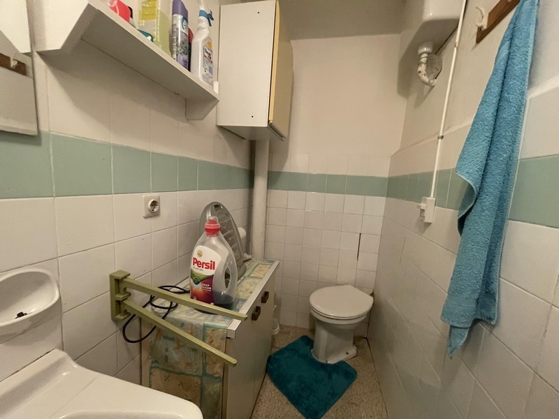 Piccolo bagno con piastrelle verde chiaro e mensola