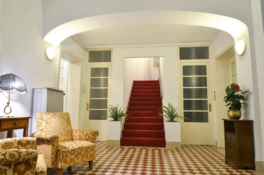 Atrio d'ingresso con scala e passatoia rossa