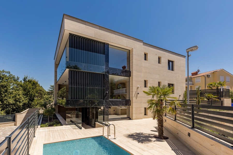 Appartamento al piano terra a Krk con piscina e palma davanti alla facciata in pietra