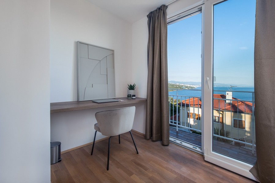 Postazione di lavoro alla finestra con balcone e vista mare