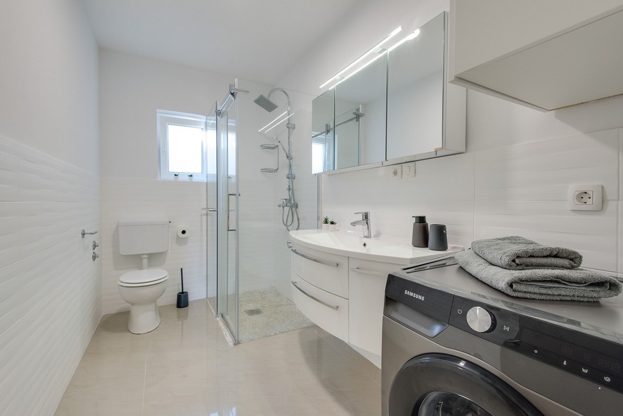 Bagno con doccia, WC e lavatrice
