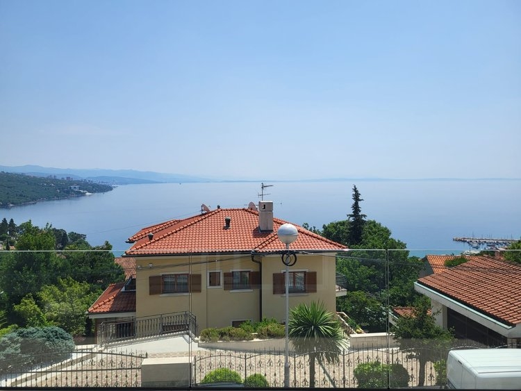 Casa vicina gialla con tetto di tegole davanti al mare aperto