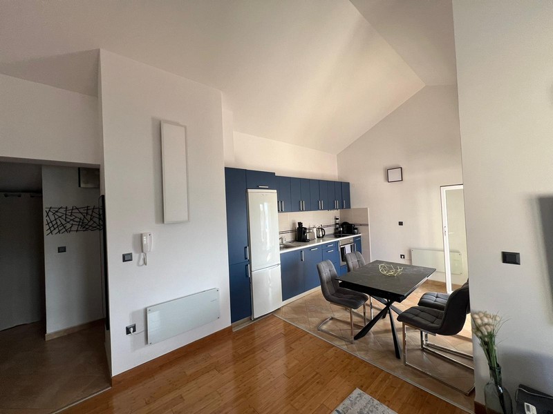 Angolo cottura blu con tavolo da pranzo sotto il soffitto spiovente