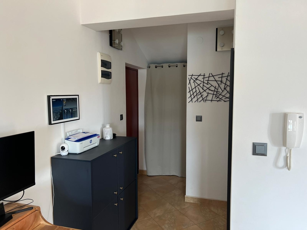 Corridoio con cassettiera scura e tenda davanti alla nicchia
