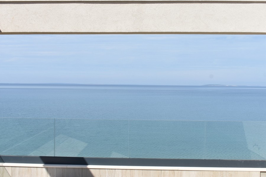 Mare calmo dietro il parapetto in vetro della terrazza