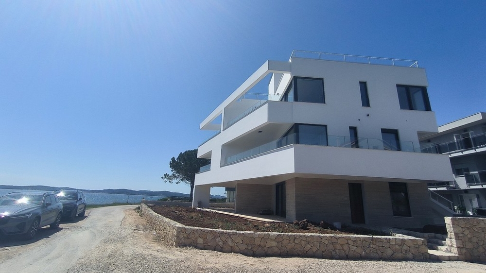Edificio nuovo bianco con balconi a sbalzo sull'acqua