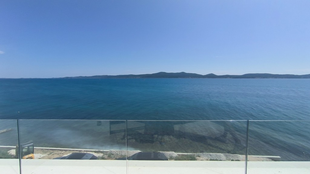 Parapetto in vetro della terrazza davanti all'acqua azzurro intenso