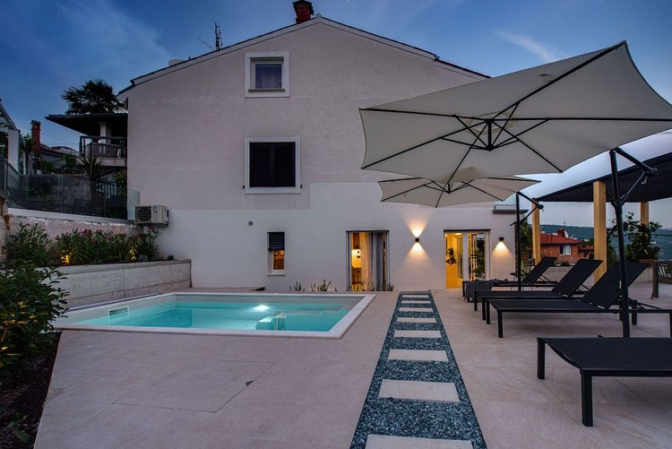 Piscina e terrazza con lettini al crepuscolo