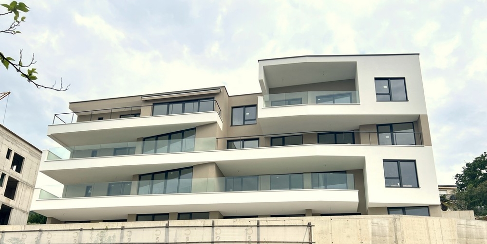 Edificio nuovo con balconi curvi sotto un cielo nuvoloso