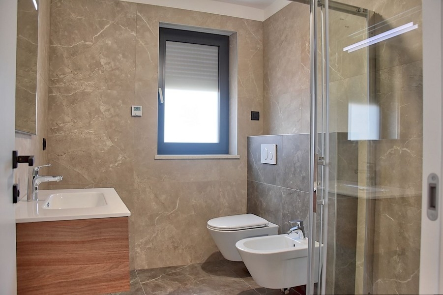 Elegante bagno in un attico in vendita in Istria, con rubinetteria moderna e piastrelle in marmo.