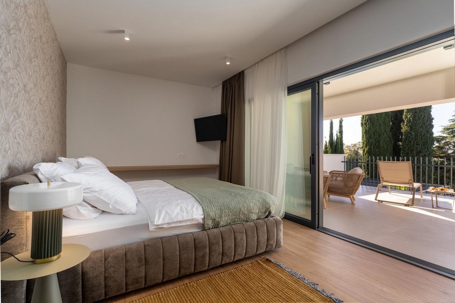 Camera da letto con ampia vetrata e accesso alla terrazza in un appartamento di lusso in Istria
