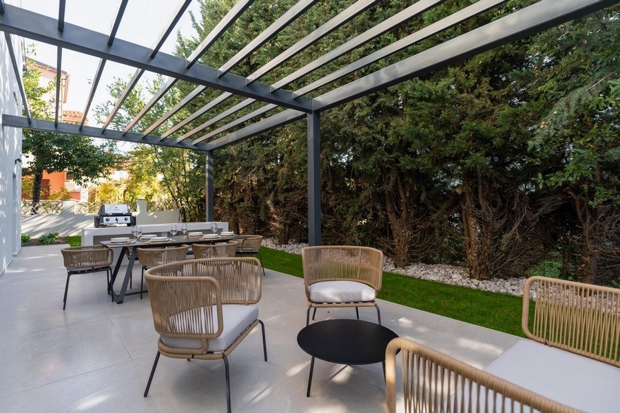 Vista esterna della terrazza con cucina estiva e zona pranzo in appartamento di lusso in Istria circondato dal verde