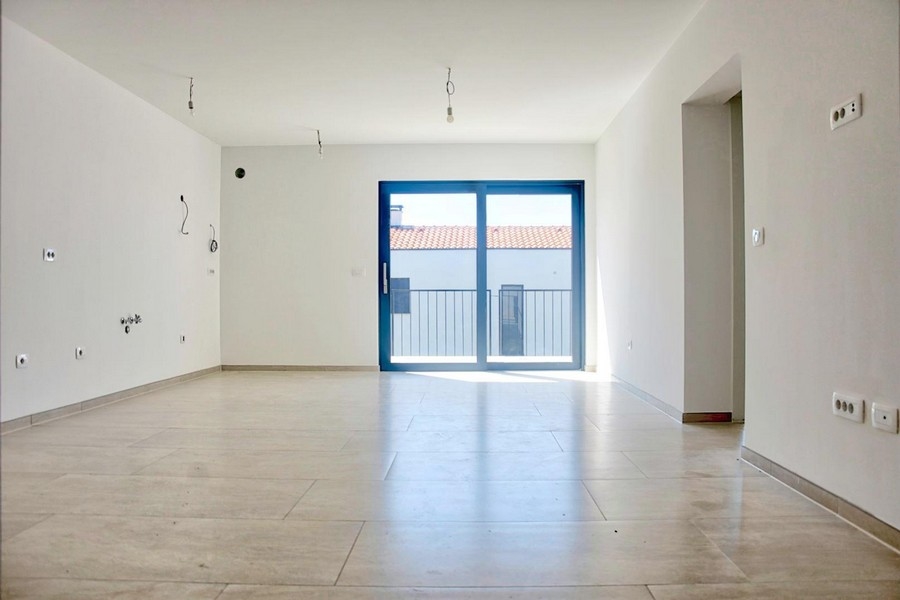 Locale vuoto e luminoso con grandi porte finestre e pavimento piastrellato, offerta immobiliare a Porec