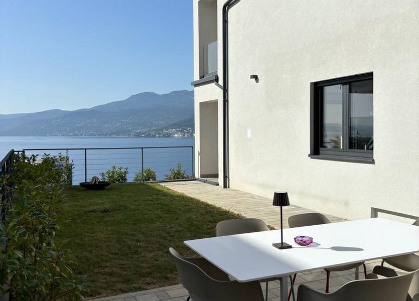 Terrazza con tavolo e sedie bianchi e vista sul mare, appartamento in vendita a Rijeka, Croazia.