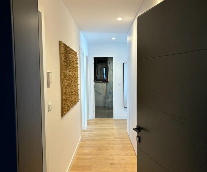 Corridoio in un appartamento con pavimento in legno e una parete d'arte, in vendita a Rijeka, Croazia.