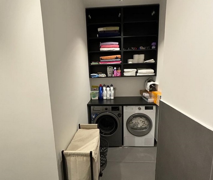 Zona lavanderia con lavatrice e armadio a muro per asciugamani, parte di un appartamento in vendita a Rijeka, Croazia.