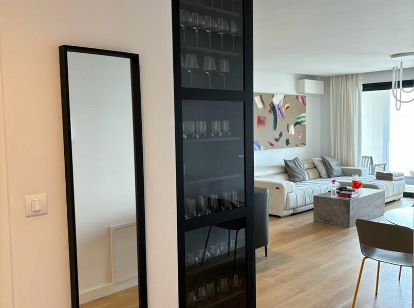 Elegante cantinetta accanto a una porta di vetro nera, dettaglio di un appartamento in vendita a Rijeka, Croazia.