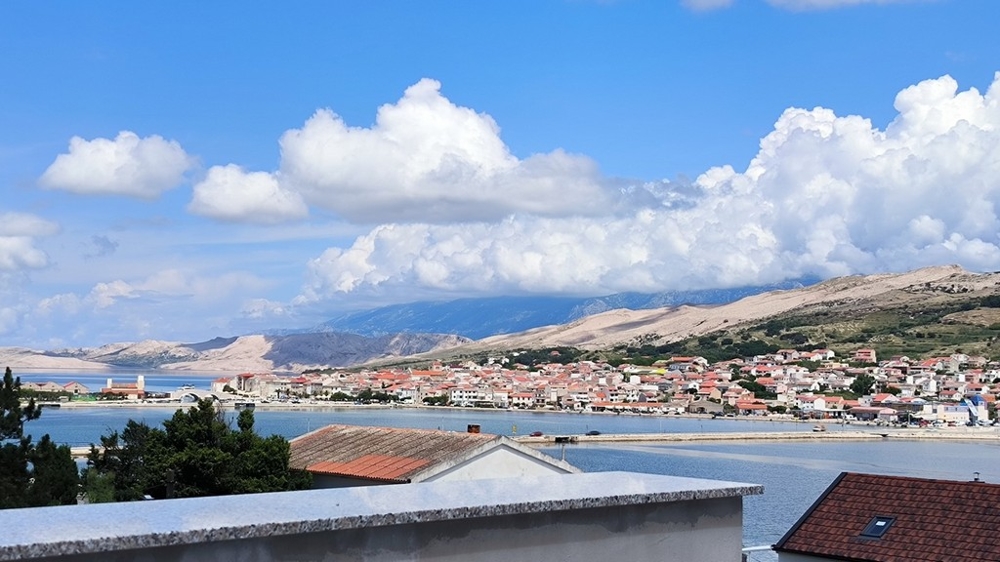 Vista esterna dell'area parcheggio di un appartamento in vendita a Pag, Croazia, con vialetto di ghiaia