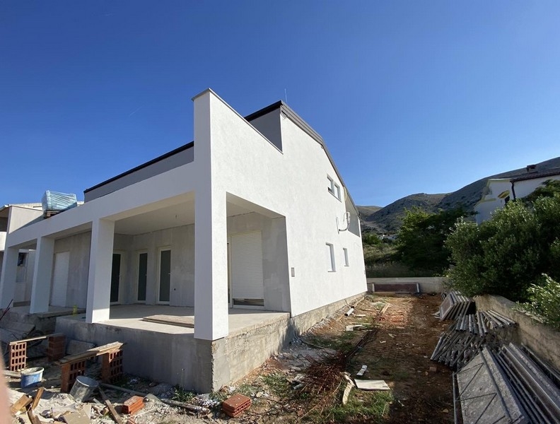 Vista esterna della casa di nuova costruzione con terrazza coperta