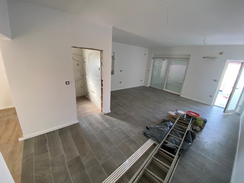 Zona giorno vuota con pavimento piastrellato grigio nell'appartamento in vendita a Pag, Croazia