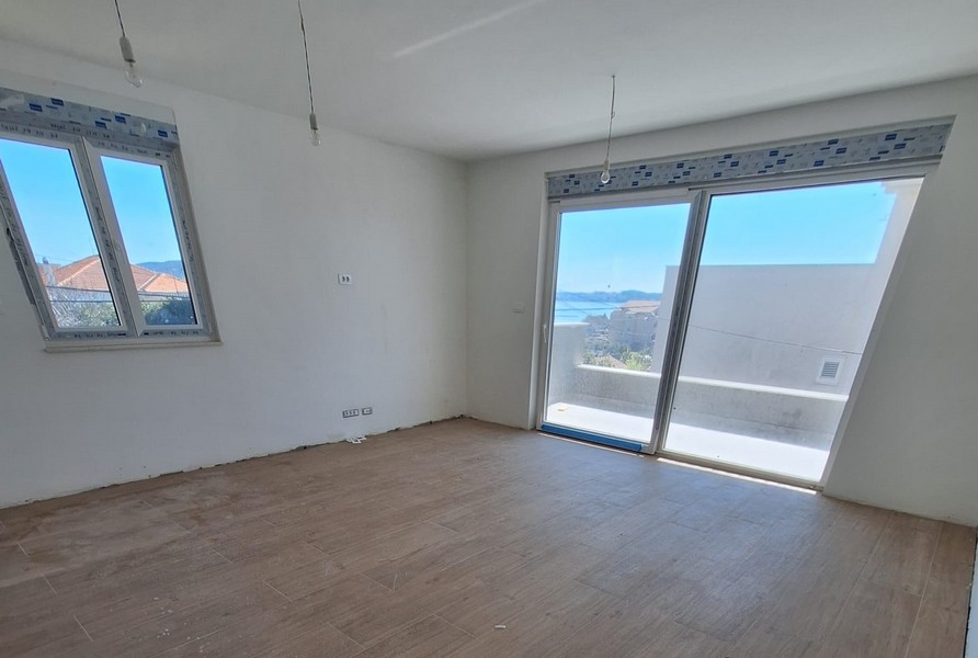 Stanza vuota con parquet e vetrata con vista mare