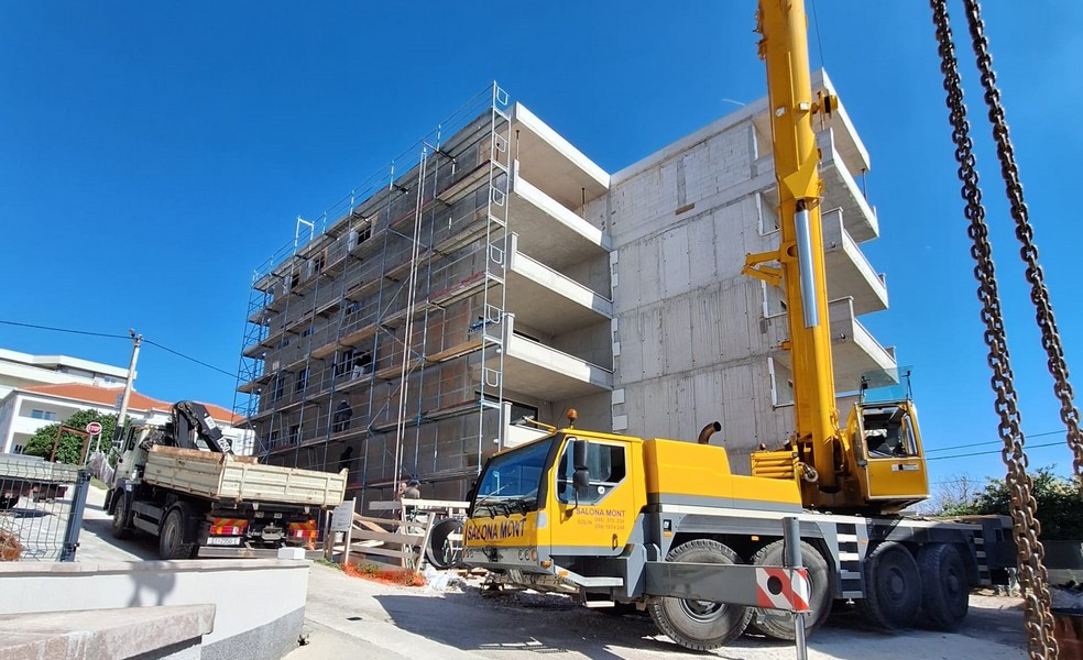 Edificio di appartamenti al grezzo con gru nel cantiere in Croazia