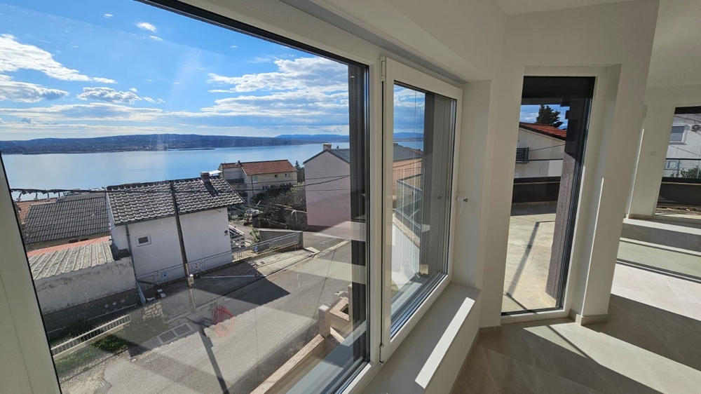 Vista interna dell'appartamento in vendita a Crikvenica, con vista sul mare attraverso finestre a tutta altezza