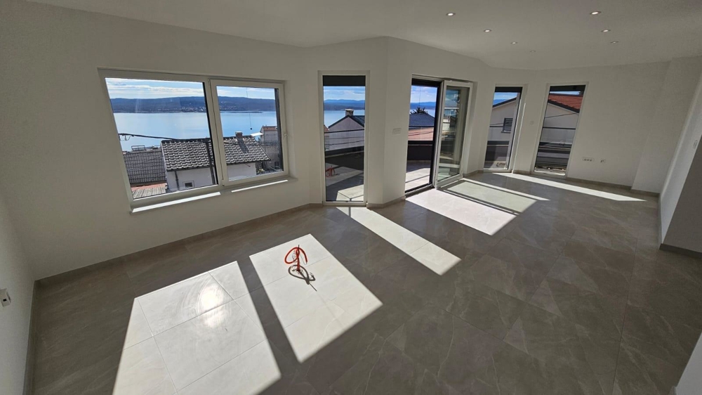 Luminoso soggiorno vuoto nell'appartamento in vendita a Crikvenica, Quarnaro, con grandi finestre e vista mare